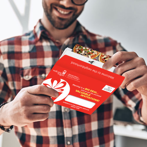 Man opening Welcome Wagon envelope with gift inserts