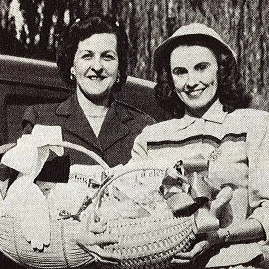 history-EDIT vintage black and white photo of two smiling women holding gift baskets