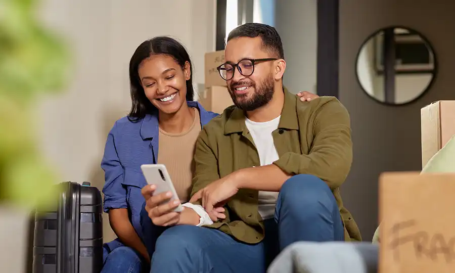couple-moving-iStock-2172319961 photo of a couple looking at a smartphone after moving